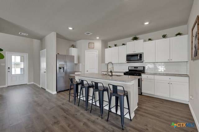 kitchen featuring white cabinets, sink, dark hardwood / wood-style floors, an island with sink, and appliances with stainless steel finishes