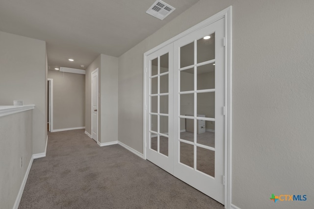 hallway with french doors and light colored carpet