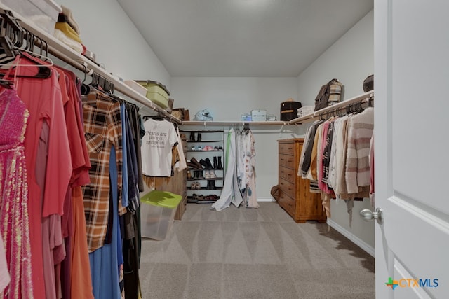 walk in closet with light carpet