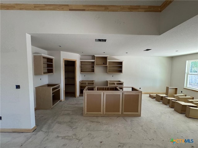 kitchen featuring a center island, baseboards, open shelves, and visible vents