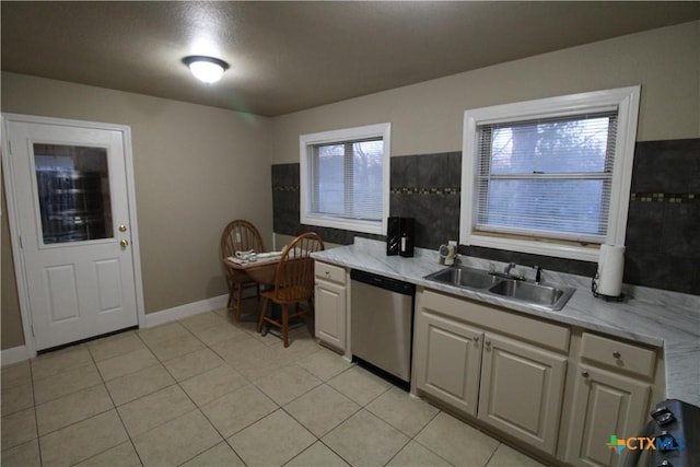 kitchen featuring dishwasher, light tile patterned floors, a wealth of natural light, and sink