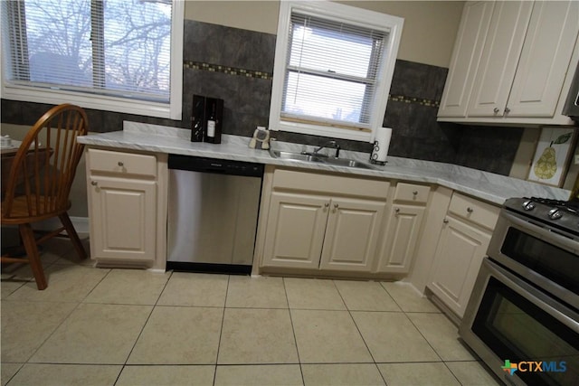 kitchen featuring white cabinets, light tile patterned flooring, sink, and appliances with stainless steel finishes