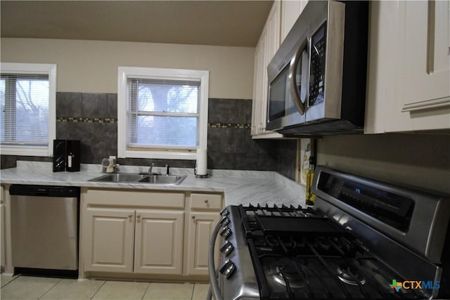 kitchen featuring light tile patterned flooring, appliances with stainless steel finishes, and sink