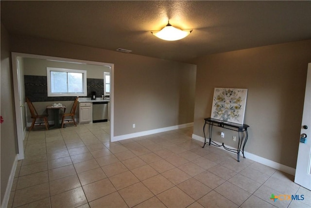 unfurnished living room with a textured ceiling and light tile patterned flooring