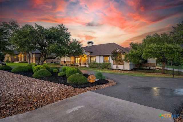1448 Decanter Dr, New Braunfels, TX 78132 - view of front of home featuring curved driveway, a chimney, and stucco siding