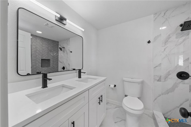 bathroom featuring toilet, vanity, and tiled shower