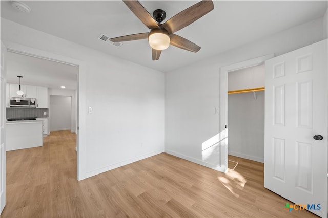 unfurnished bedroom featuring a closet, light wood-type flooring, and ceiling fan