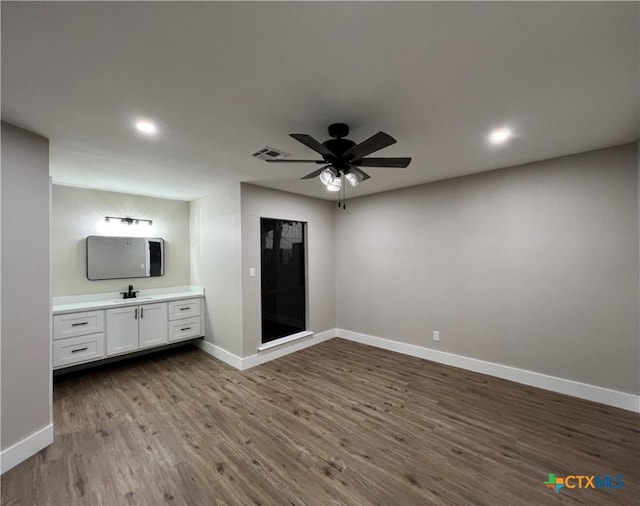 unfurnished bedroom with hardwood / wood-style floors, ceiling fan, and sink