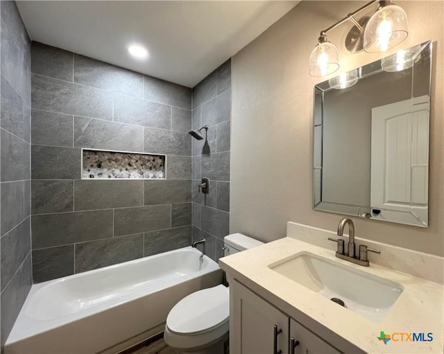 full bathroom featuring vanity, tiled shower / bath combo, and toilet