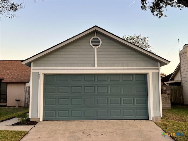 view of garage at dusk