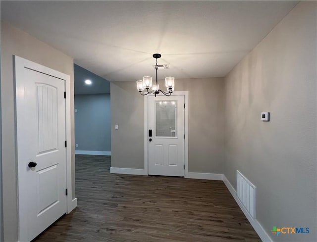 unfurnished dining area featuring dark hardwood / wood-style floors and an inviting chandelier