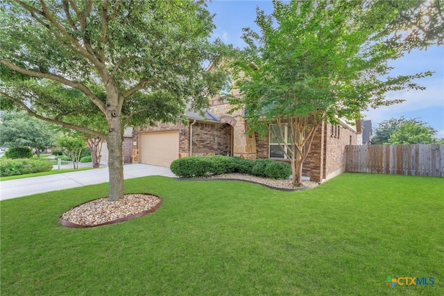 obstructed view of property featuring a garage and a front yard