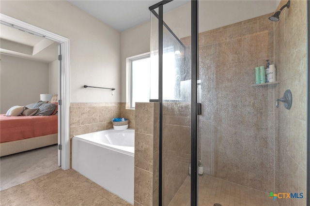 bathroom featuring tile patterned floors, plus walk in shower, and tile walls