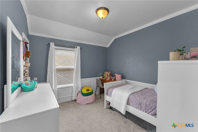 carpeted bedroom with lofted ceiling and crown molding