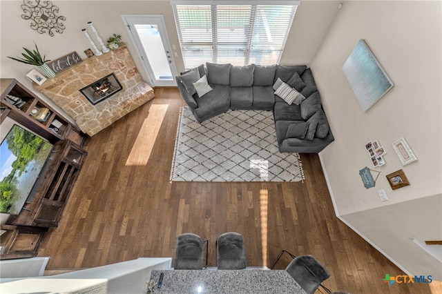 living room with dark wood-type flooring and a fireplace