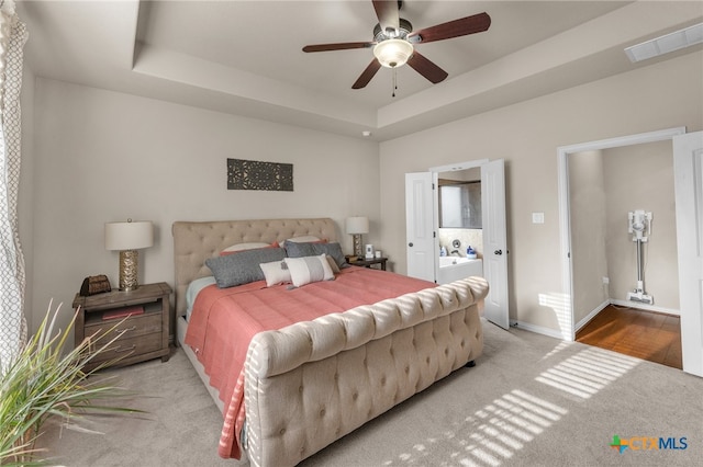 bedroom with carpet floors, ceiling fan, and a raised ceiling