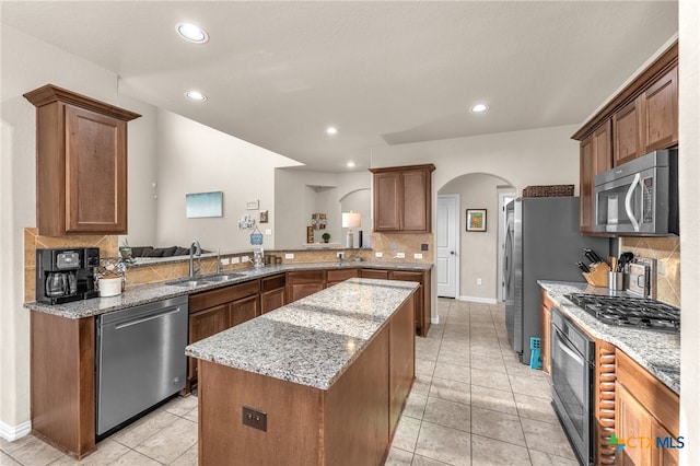 kitchen featuring decorative backsplash, kitchen peninsula, appliances with stainless steel finishes, and sink