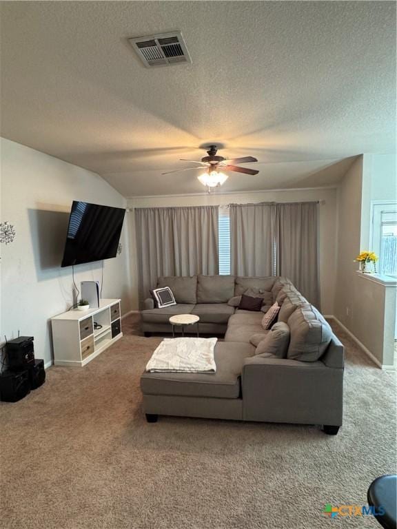 living room with baseboards, visible vents, ceiling fan, carpet, and a textured ceiling