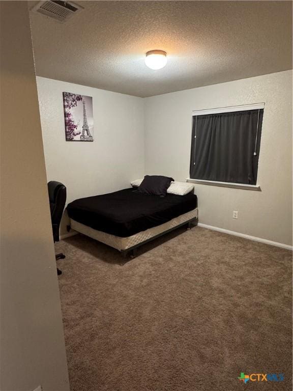 bedroom with carpet floors, baseboards, visible vents, and a textured ceiling