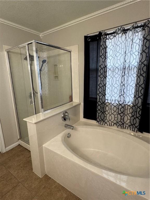 full bath with a stall shower, ornamental molding, tile patterned floors, a textured ceiling, and a bath