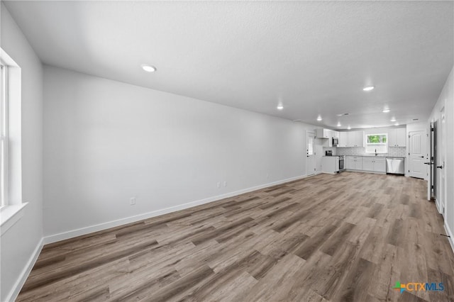 614 S 24th St, Temple, TX 76501 - unfurnished living room with recessed lighting, light wood-type flooring, and baseboards