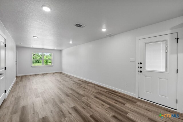 614 S 24th St, Temple, TX 76501 - unfurnished room with wood finished floors, baseboards, a textured ceiling, and recessed lighting