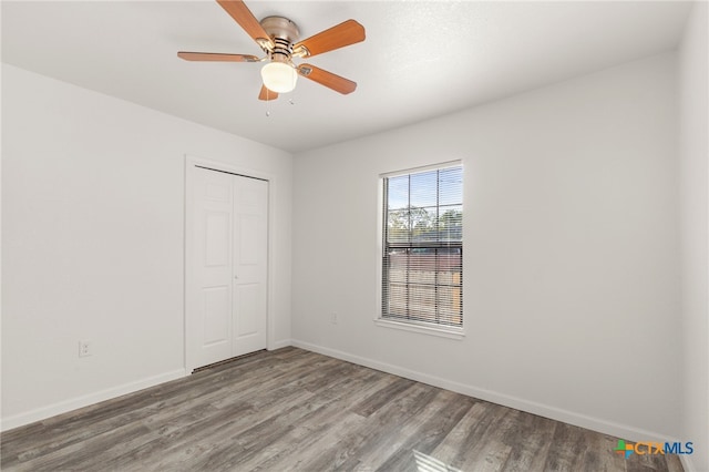 empty room featuring a ceiling fan, wood finished floors, and baseboards