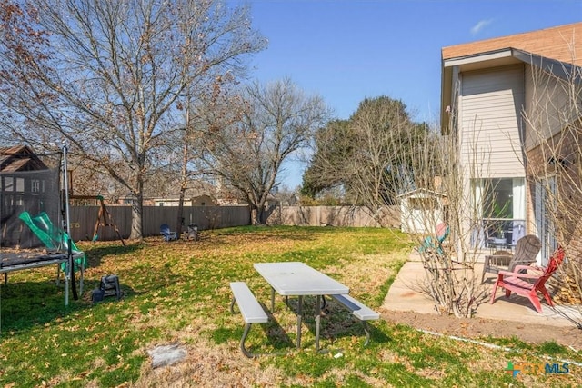 view of yard featuring a trampoline and a patio