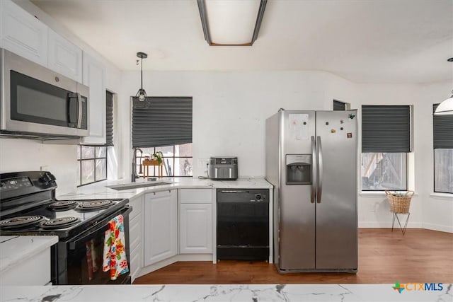 kitchen with white cabinetry, sink, hanging light fixtures, and black appliances