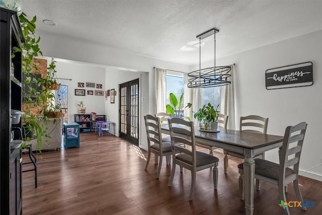 dining room with dark hardwood / wood-style floors, a textured ceiling, and french doors