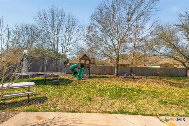 view of yard with a trampoline and a playground