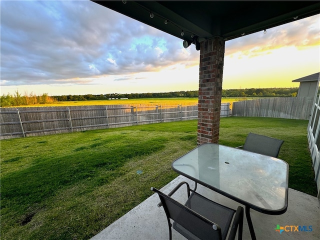 yard at dusk featuring a patio