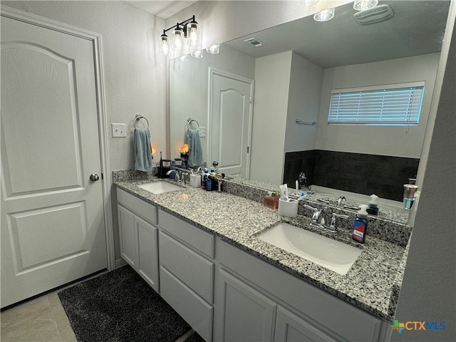 bathroom featuring vanity, a tub to relax in, and tile patterned floors