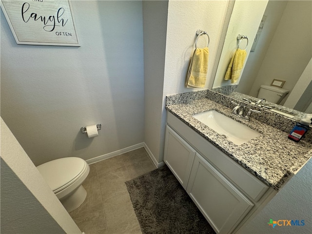 bathroom with vanity, tile patterned floors, and toilet