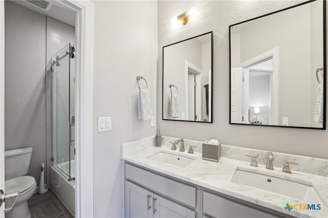 13900 Zink Bnd Unit 61, Austin, TX 78717 - bathroom with toilet, double vanity, a textured wall, and shower / bath combination with glass door