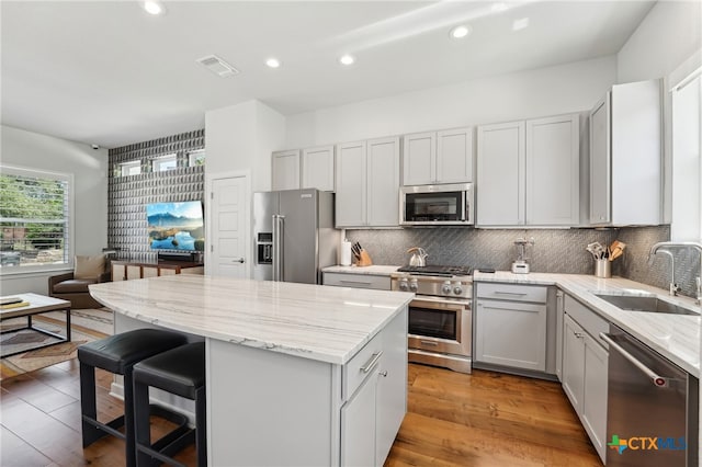 13900 Zink Bnd Unit 61, Austin, TX 78717 - kitchen featuring high end appliances, a sink, a kitchen island, light stone countertops, and decorative backsplash