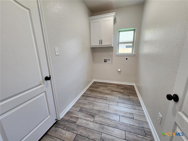 719 Eagle Claw Dr, Salado, TX 76571 - laundry area with hookup for an electric dryer, cabinet space, washer hookup, wood finished floors, and baseboards