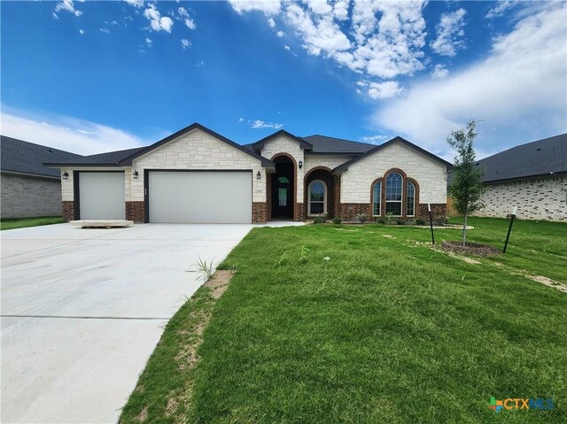 719 Eagle Claw Dr, Salado, TX 76571 - french country style house featuring a garage, driveway, a front yard, and brick siding