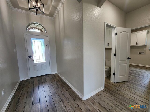 719 Eagle Claw Dr, Salado, TX 76571 - foyer entrance featuring a chandelier, dark wood finished floors, crown molding, and baseboards