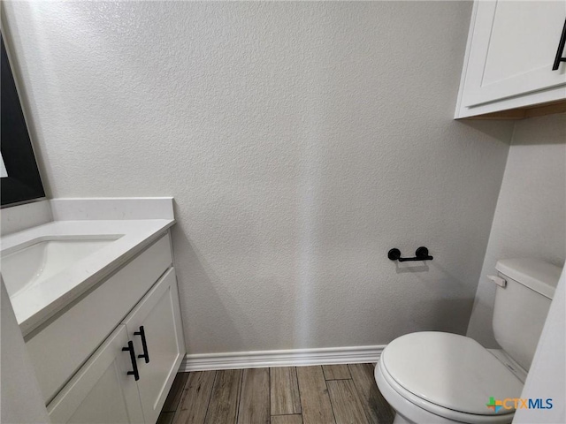 719 Eagle Claw Dr, Salado, TX 76571 - bathroom with vanity, wood finished floors, toilet, baseboards, and a textured wall