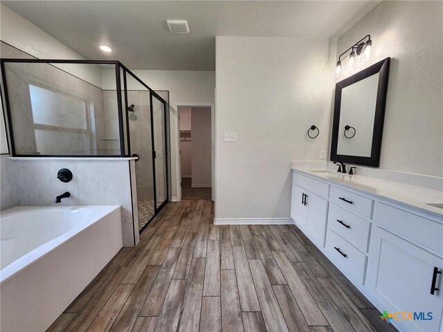 719 Eagle Claw Dr, Salado, TX 76571 - bathroom with a shower stall, a garden tub, double vanity, wood finished floors, and a spacious closet