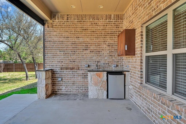 view of patio / terrace featuring fence and a sink