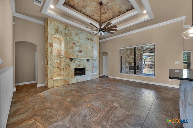 unfurnished living room featuring visible vents, a ceiling fan, arched walkways, and a raised ceiling