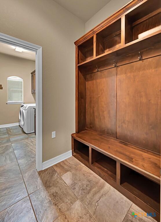 mudroom featuring washing machine and clothes dryer and baseboards