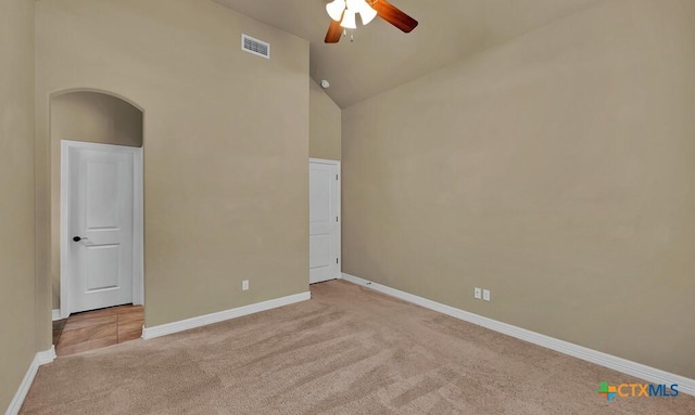 spare room featuring high vaulted ceiling, visible vents, baseboards, ceiling fan, and light colored carpet