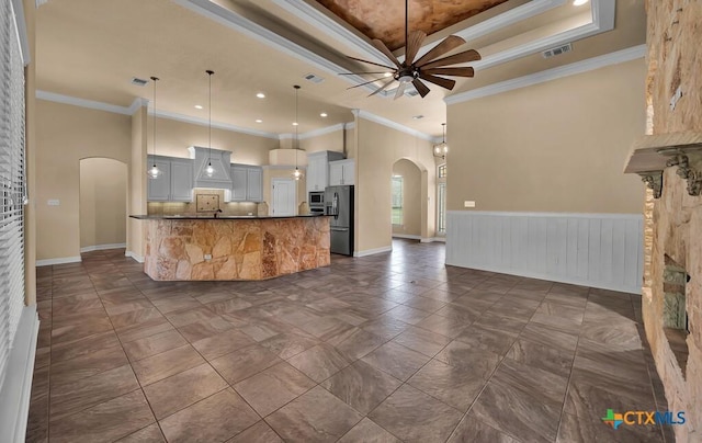 kitchen featuring black fridge with ice dispenser, visible vents, ceiling fan, arched walkways, and open floor plan