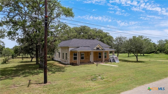 210 Julia St, Yoakum, TX 77995 - country-style home featuring a porch, a front yard, and roof with shingles