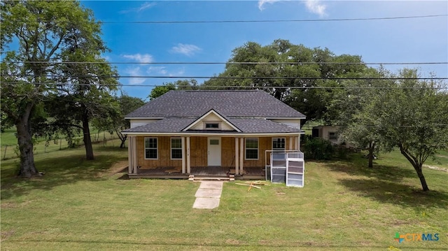 210 Julia St, Yoakum, TX 77995 - view of front of home with covered porch, a shingled roof, and a front lawn