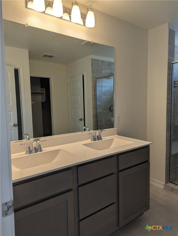 4177 Harper Lee Ln, New Braunfels, TX 78130 - bathroom featuring double vanity, a shower stall, and tile patterned floors