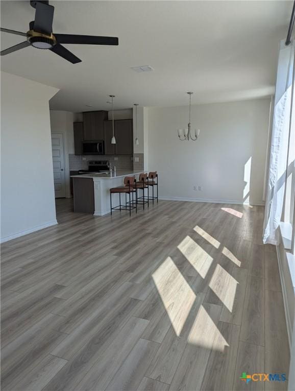 4177 Harper Lee Ln, New Braunfels, TX 78130 - living area featuring a chandelier, a ceiling fan, light wood finished floors, and baseboards